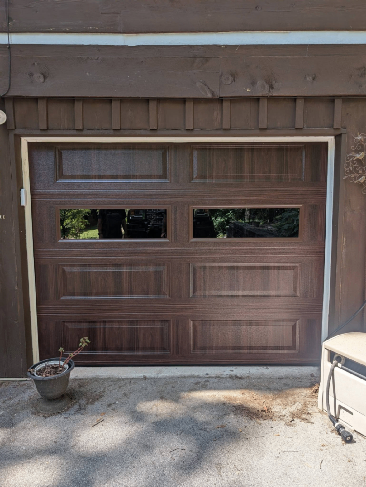 Woodgrain raised-panel garage door with window inserts