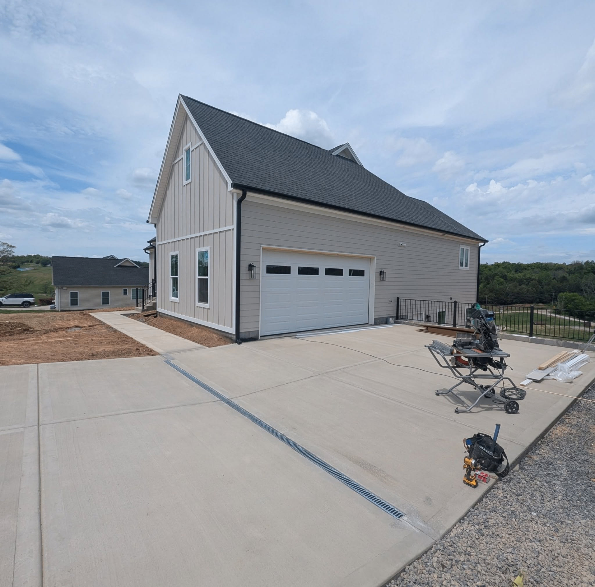 New construction home with white two-car garage door and board-and-batten siding